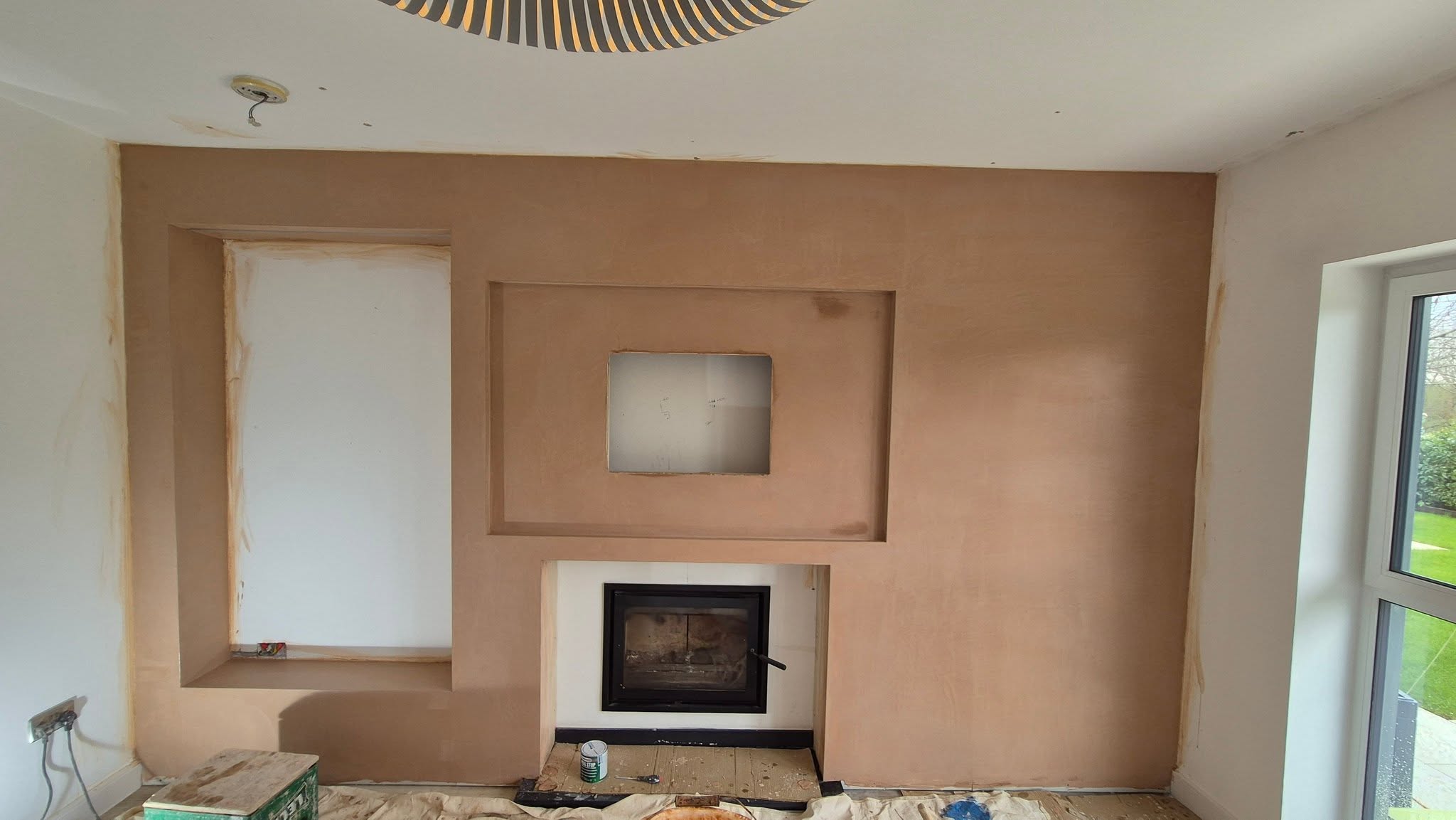 The frame boarded with plasterboard, niches formed around the wood burner
