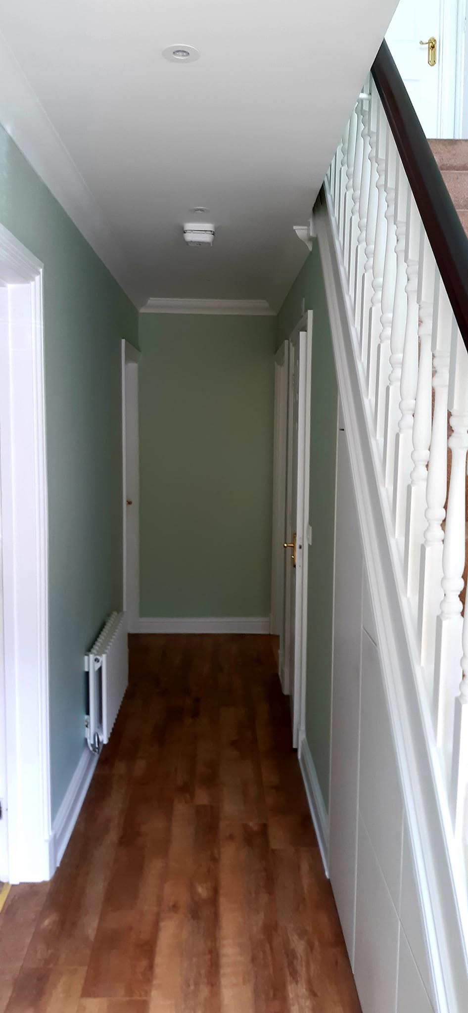 Sage green stair wall with white spindles