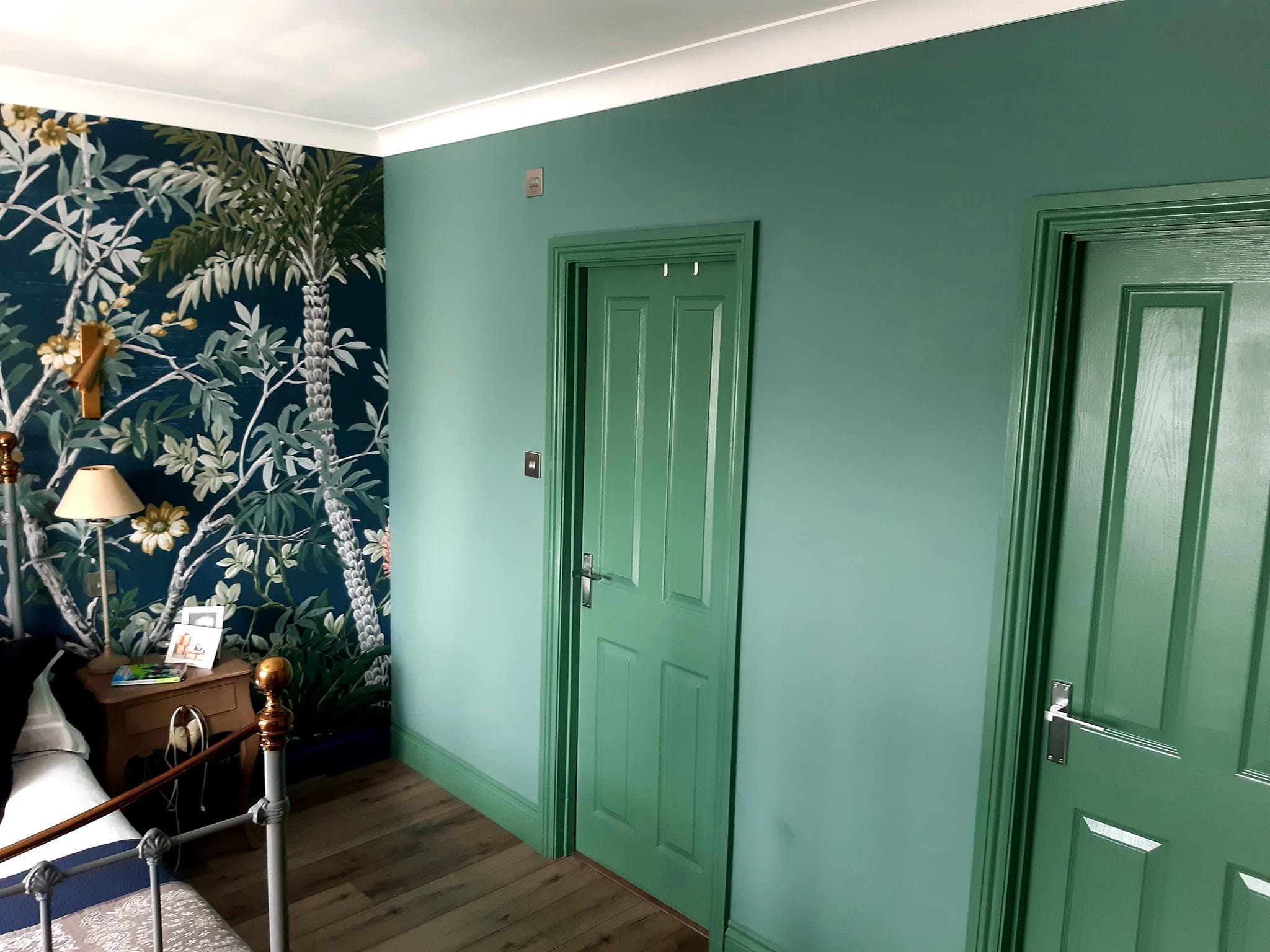 The same bedroom finished with sage green walls and green painted doors