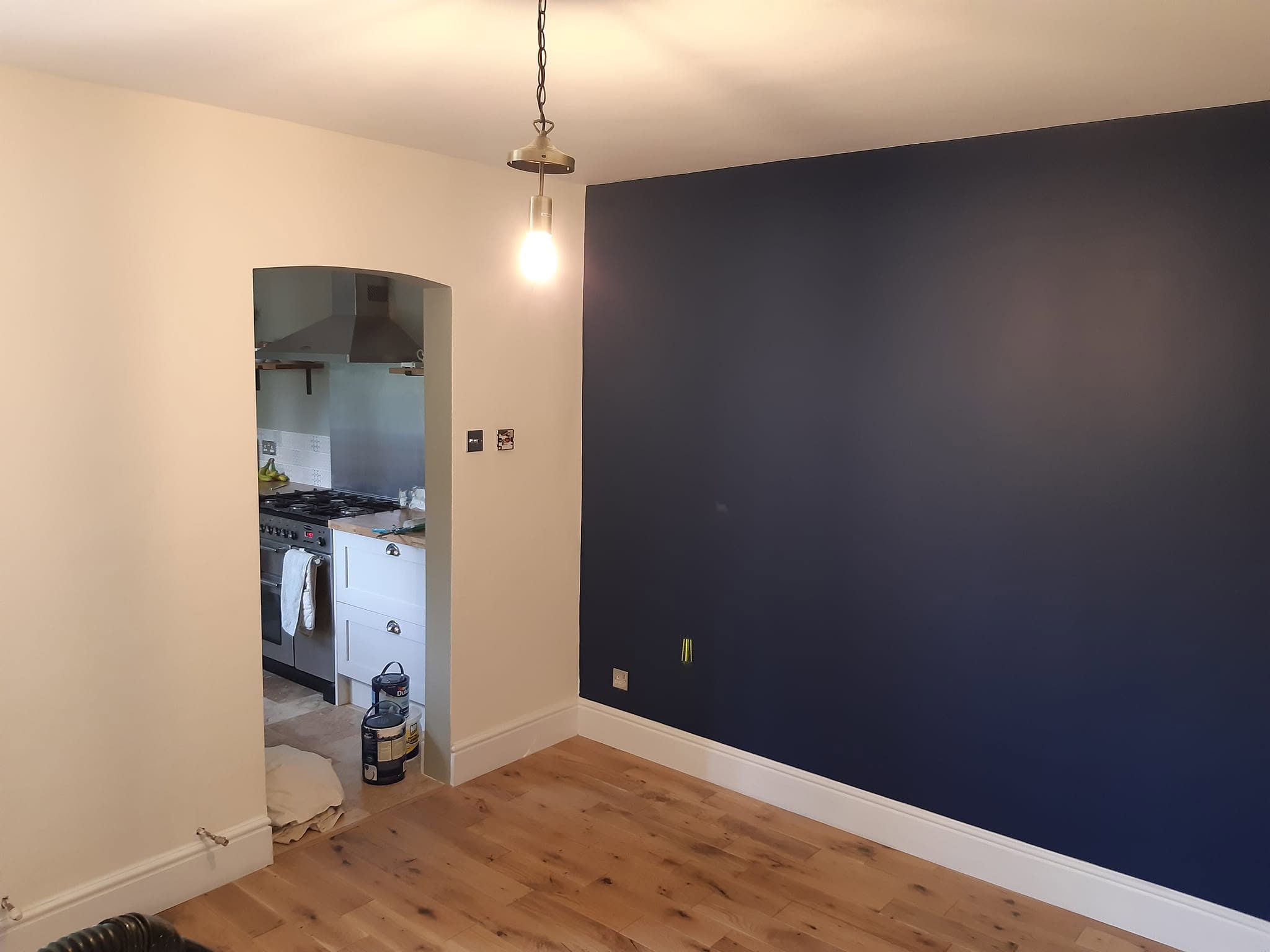 After: a navy feature wall and white walls around the arched opening
