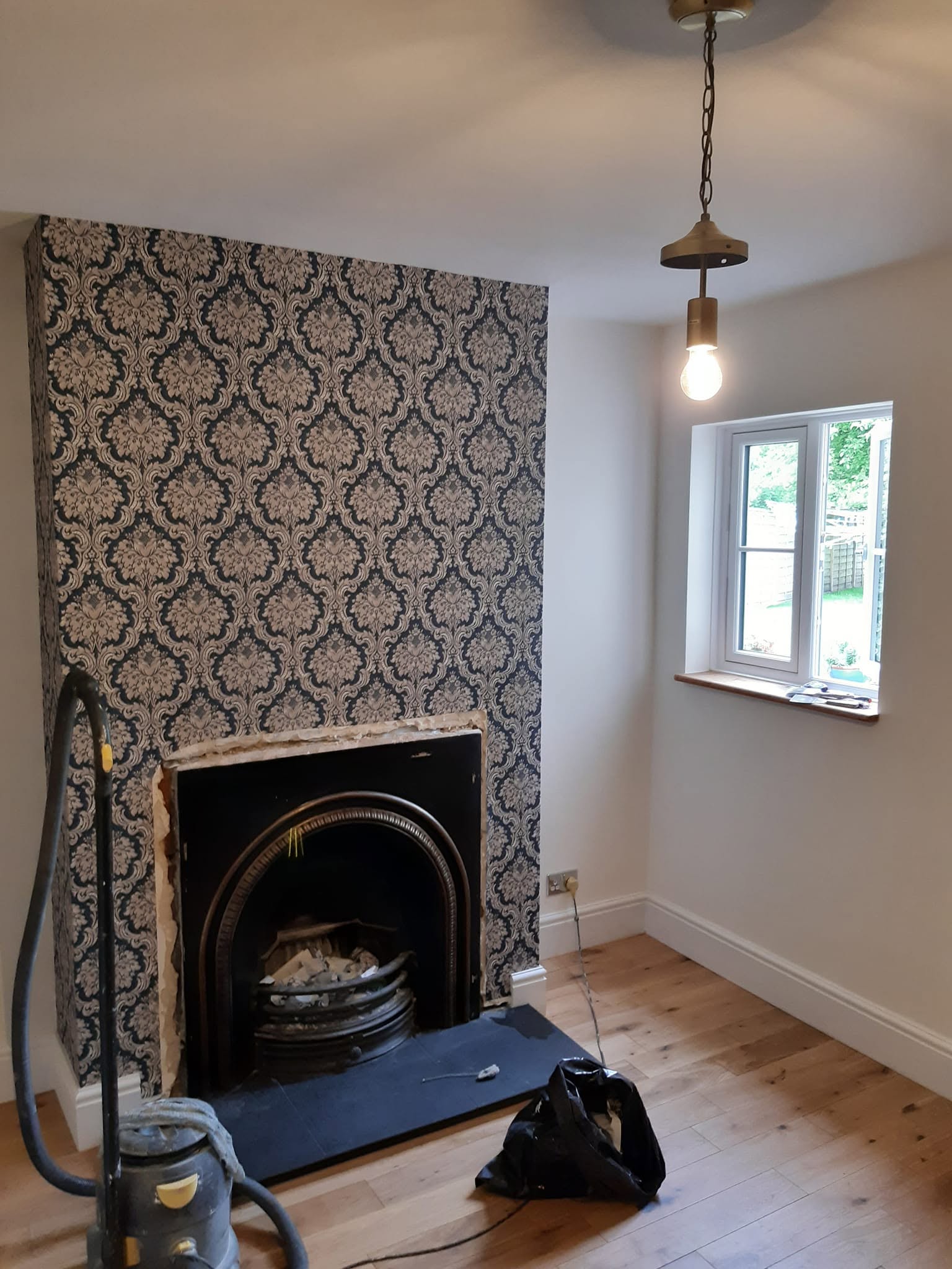 After: the chimney breast papered in damask around the fireplace, walls painted