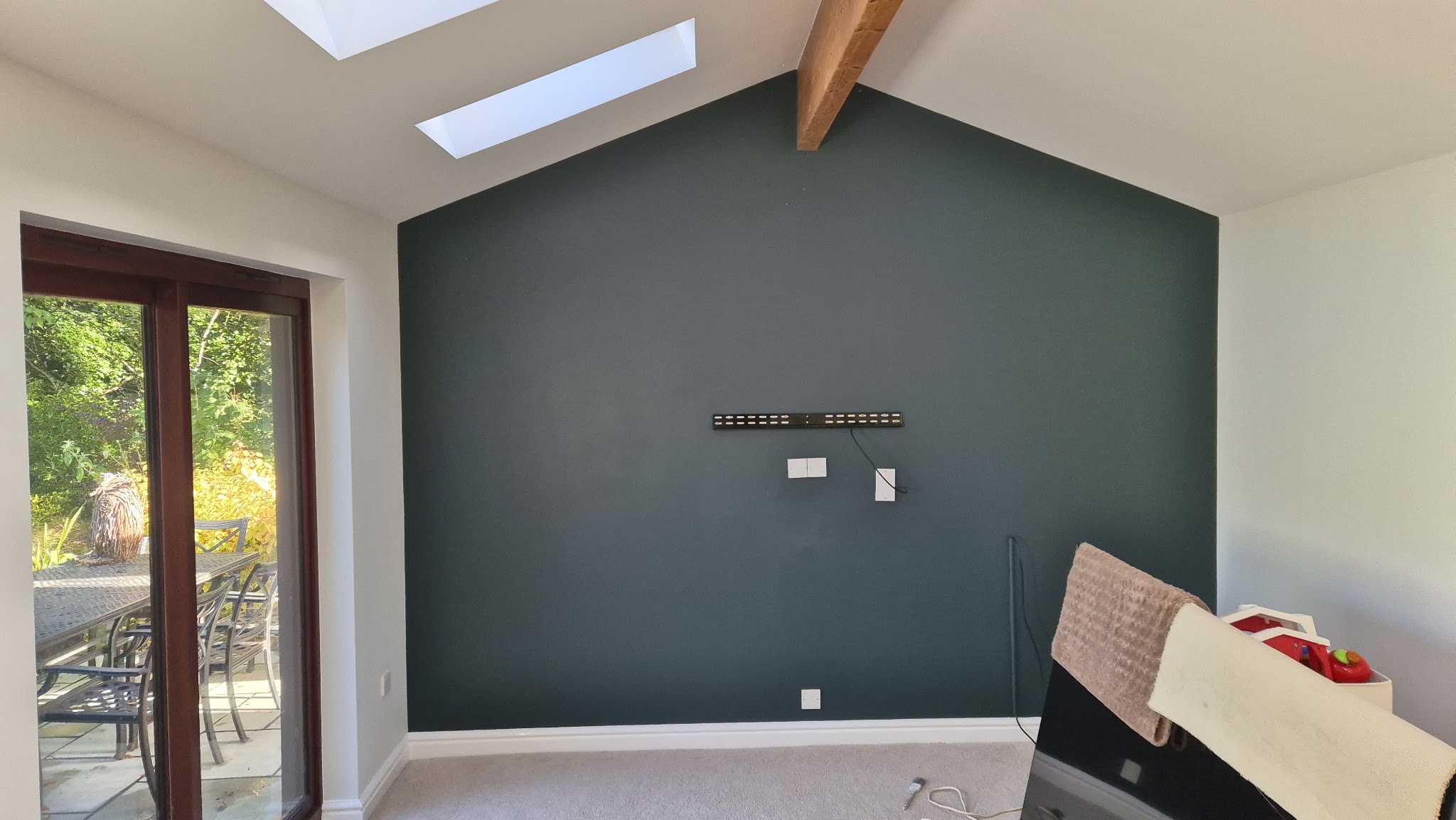 Garden room with a dark green grey feature wall and exposed beam