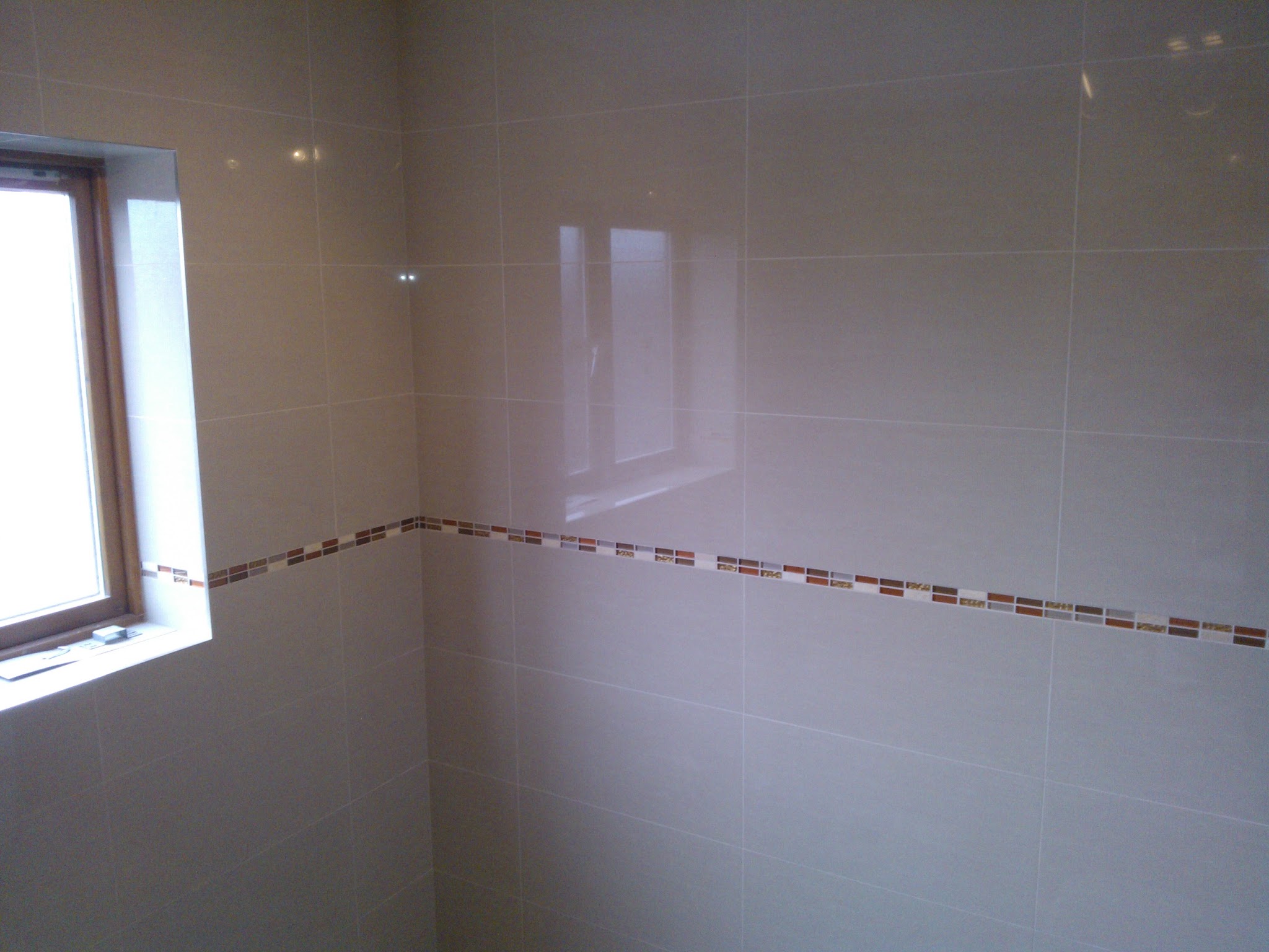Tiled wall with a mosaic border strip